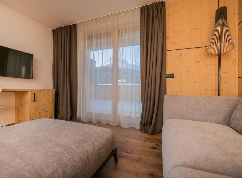 Divano con lampada, TV, mini frigo e balcone lato San Candido "Suite Penthouse Caminetto"