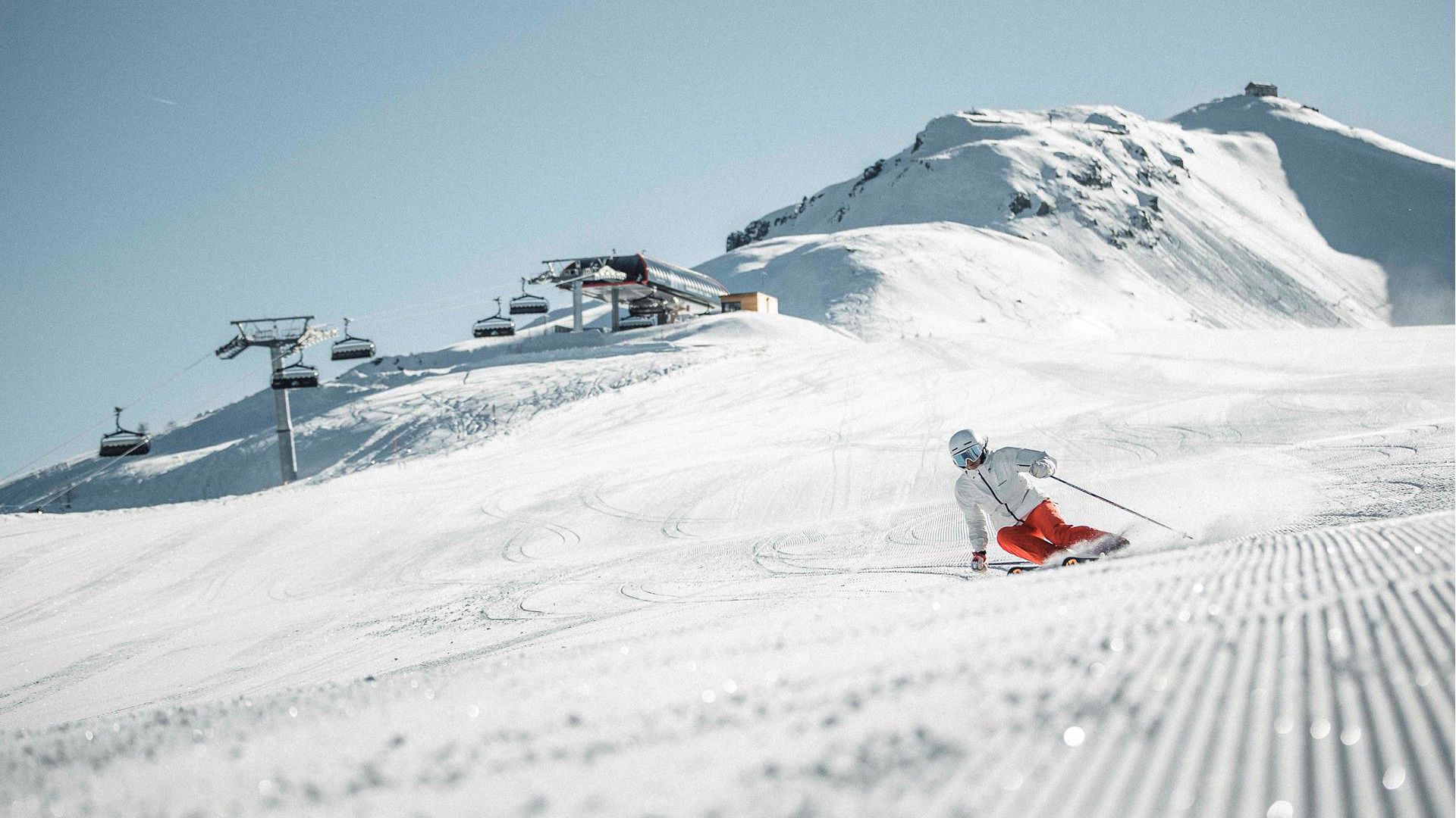 A man is skiing down a ski slope in the Drei Zinnen ski area
