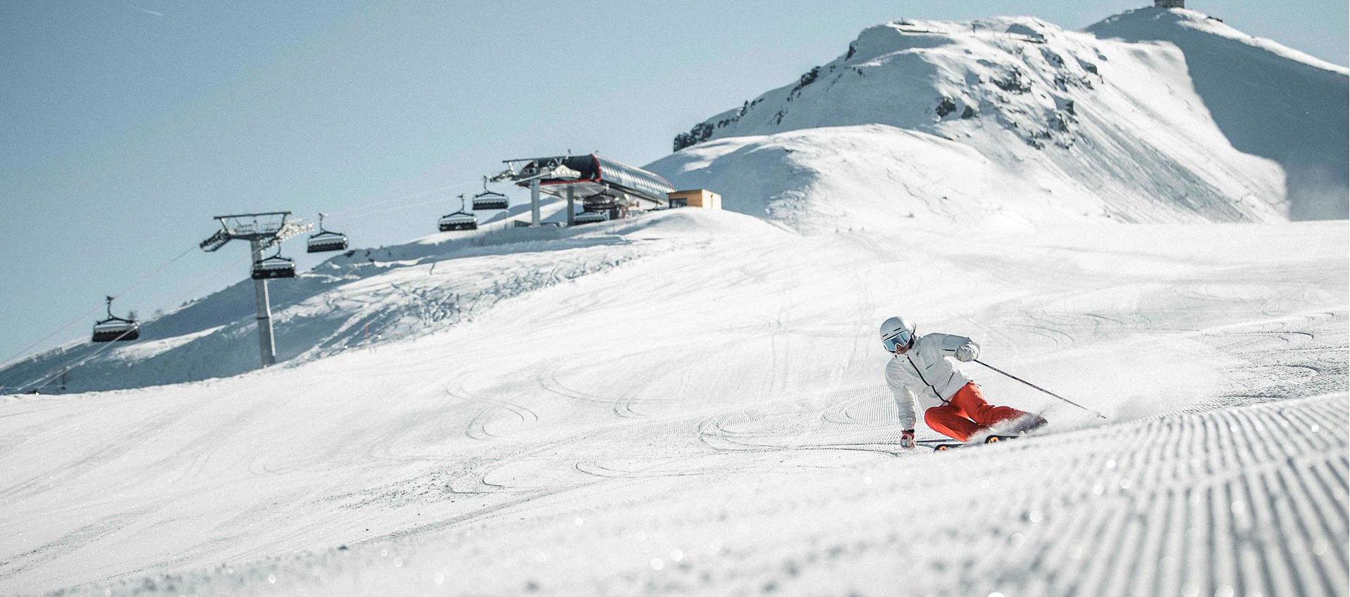 Ein Mann fährt mit seinen Skiern eine Skipiste im Skigebiet Drei Zinnen hinunter