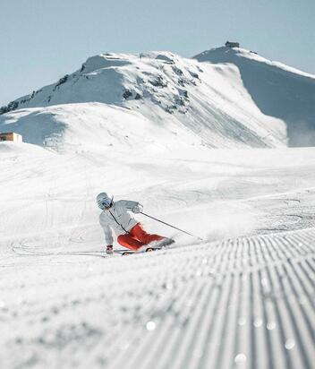 Ein Mann fährt mit seinen Skiern eine Skipiste im Skigebiet Drei Zinnen hinunter