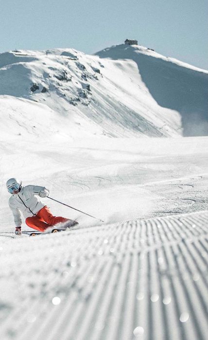 Un uomo scende una pista da sci con i suoi sci nel comprensorio sciistico delle tre cime