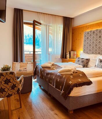 Cosy Comfort Room with double bed, armchair, mini fridge and garden-side balcony