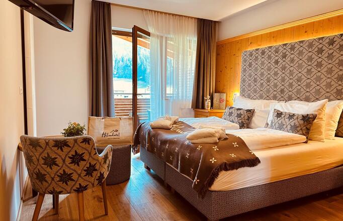 Cosy Comfort Room with double bed, armchair, mini fridge and garden-side balcony