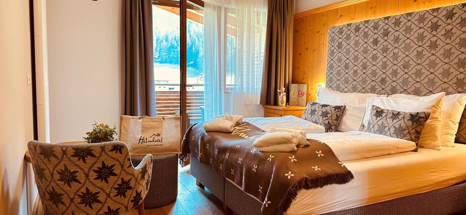 Komfortzimmer Cosy mit Doppelbett, Sessel, Minikühlschrank und Balkon Richtung Garten