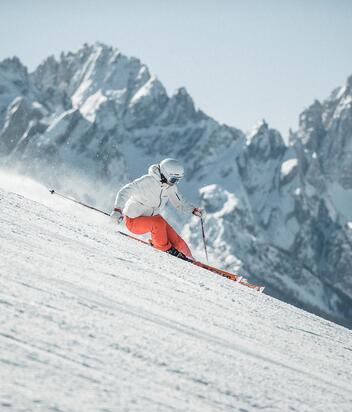 Ein Mann fährt mit seinen Skiern eine Skipiste im Skigebiet Drei Zinnen hinunter