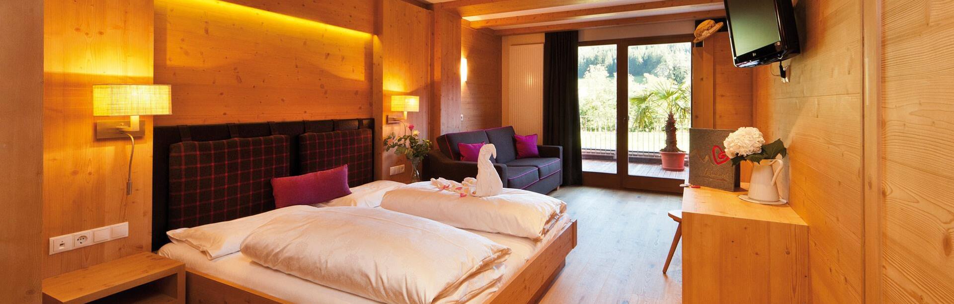Zimmer „Family Holzduft“ mit Doppelbett, Sofa, Etagenbett für Kinder, TV und Balkon zum Garten