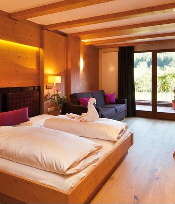 "Family Holzduft" room with double bed, sofa, bunk bed for children, TV and balcony facing the garden