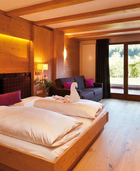 Zimmer „Family Holzduft“ mit Doppelbett, Sofa, Etagenbett für Kinder, TV und Balkon zum Garten