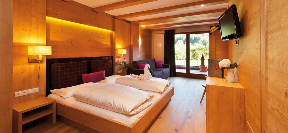Zimmer „Family Holzduft“ mit Doppelbett, Sofa, Etagenbett für Kinder, TV und Balkon zum Garten