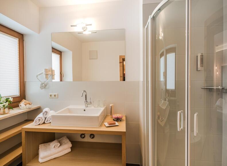 Bathroom with shower, sink and window facing the street / Versciaco