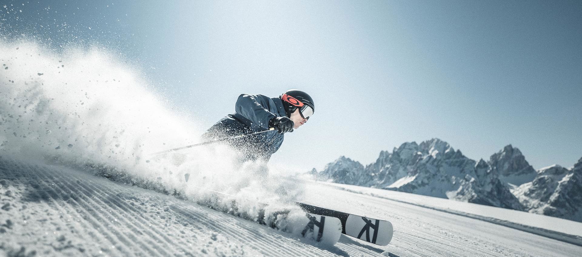 A man is skiing down a ski slope in the Drei Zinnen ski area