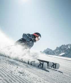 Ein Mann fährt mit seinen Skiern eine Skipiste im Skigebiet Drei Zinnen hinunter