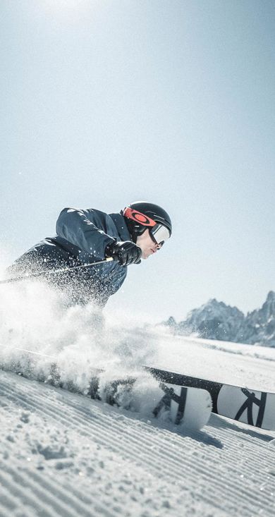 Un uomo scende una pista da sci con i suoi sci nel comprensorio sciistico delle tre cime