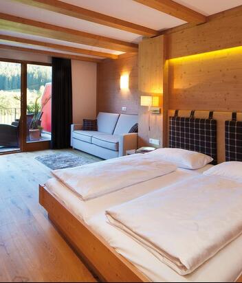Room Comfort with double bed, sofa, garden-side balcony, wardrobe, mini fridge and TV
