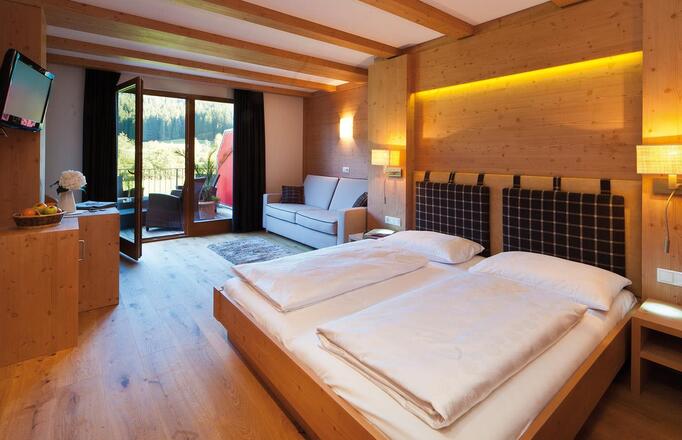 Room Comfort with double bed, sofa, garden-side balcony, wardrobe, mini fridge and TV