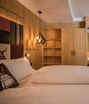 "Family Flora" room with double bed, bookshelf, wardrobe, separate children's area, and desk
