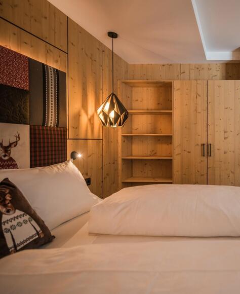 Zimmer „Family Flora“ mit Doppelbett, Bücherregal, Kleiderschrank, separatem Kinderbereich und Schreibtisch