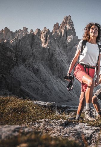 Una donna e un uomo in cammino, con le Tre Cime sullo sfondo