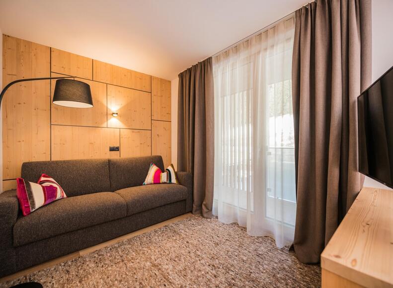 Sofa "Milli"-room with TV, lamp and street-side balcony
