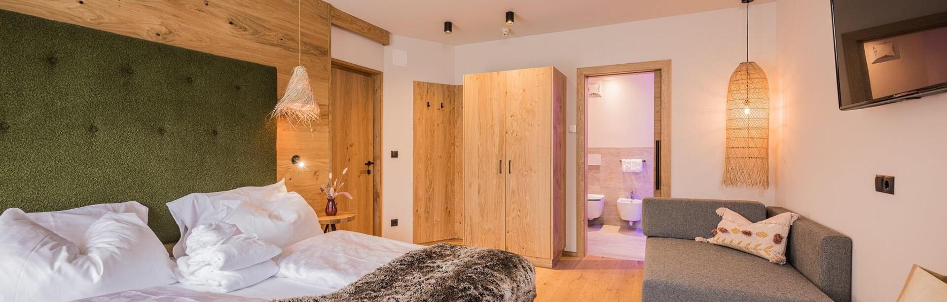 Camera dependance nature con letto, divano, armadio, TV e bagno