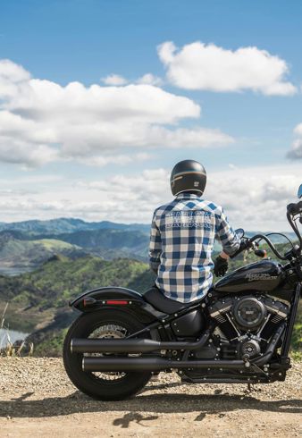 Un motociclista è seduto sulla sua moto e guarda il paesaggio montano circostante