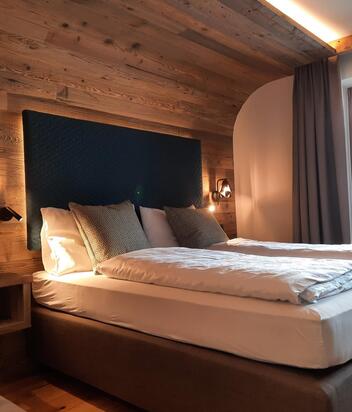 Suite dolomiti in legno con letto, divano
