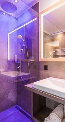 Badezimmer des Family-Zimmers Flora mit Waschbecken, Spiegel und Dusche