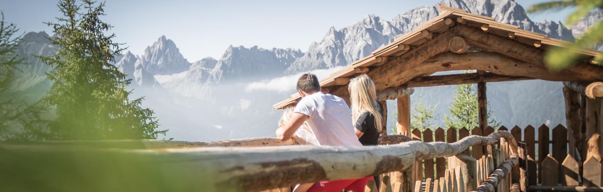 Ein Mann und eine Frau blicken auf die umliegende Berglandschaft