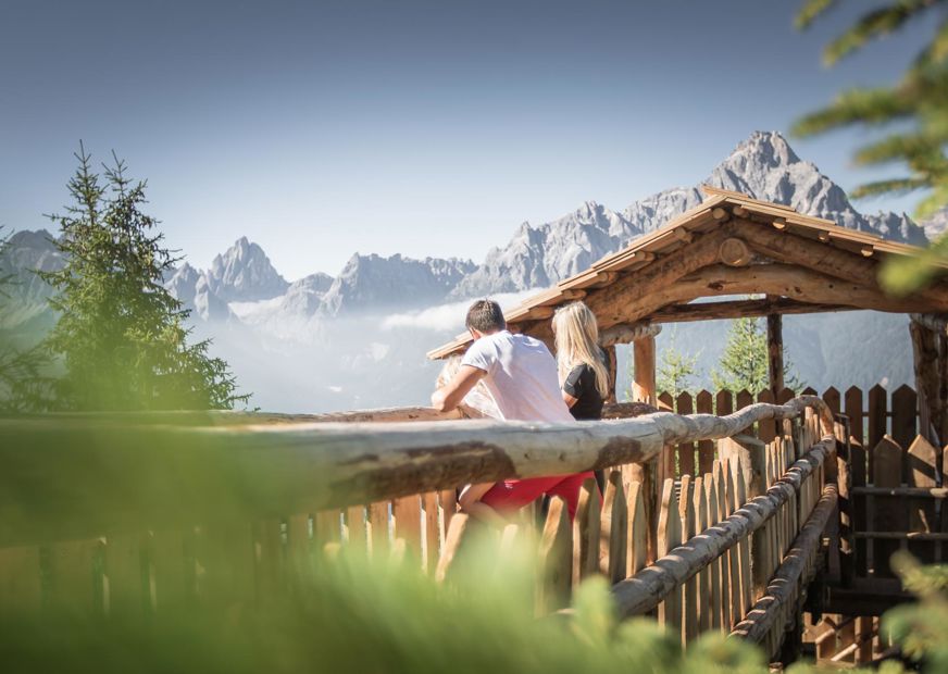 Ein Mann und eine Frau blicken auf die umliegende Berglandschaft