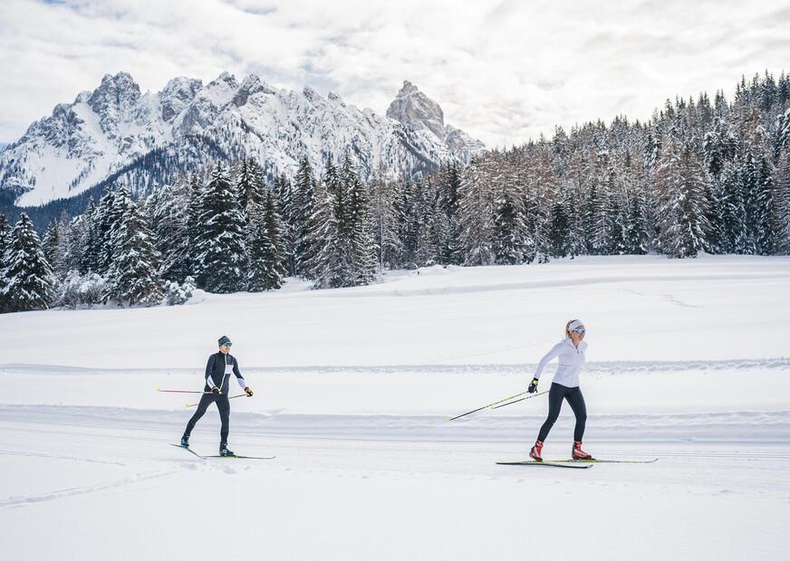 Un uomo e una donna che fanno sci di fondo nelle Dolomiti