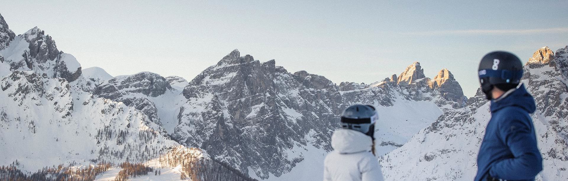 Un uomo scende una pista da sci con i suoi sci nel comprensorio sciistico delle tre cime