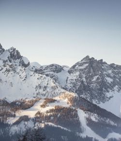Ein Mann fährt mit seinen Skiern eine Skipiste im Skigebiet Drei Zinnen hinunter