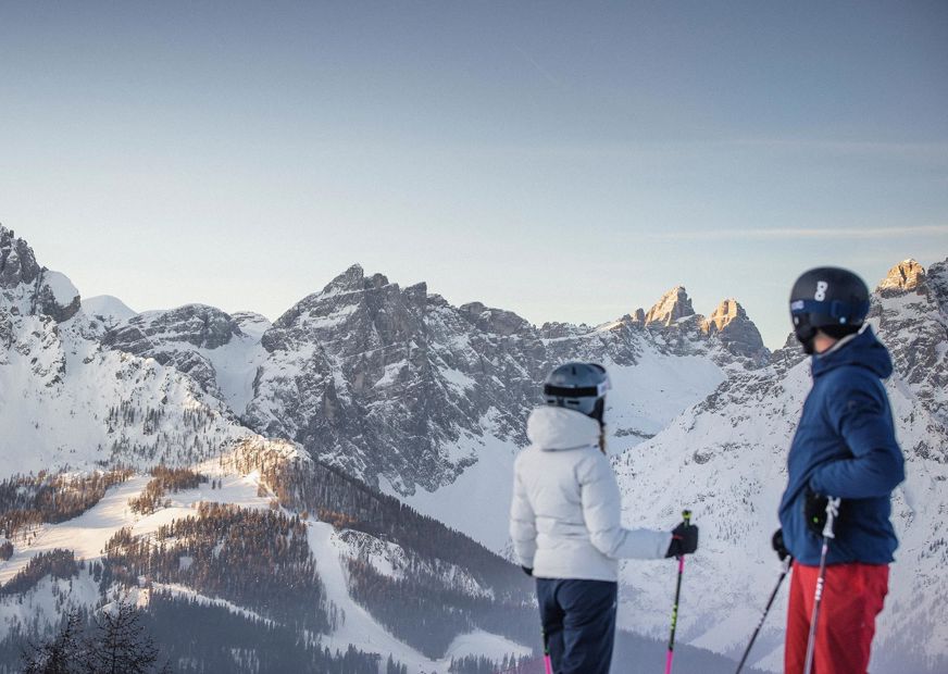 A man is skiing down a ski slope in the Drei Zinnen ski area