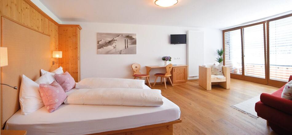 Superior Zimmer mit Doppelbett, Sofa, Schreibtisch, Schrank und Balkon Richtung Innichen