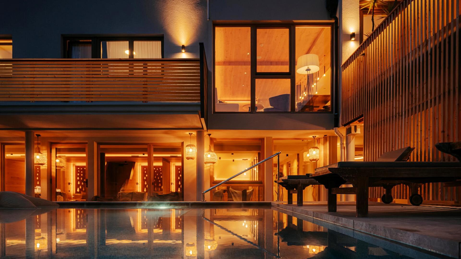 Zwei Liege am Poolrand am Abend mit warmen Licht