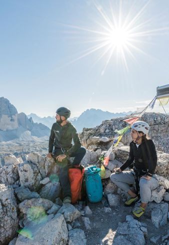 Una donna e un uomo in cammino, con le Tre Cime sullo sfondo