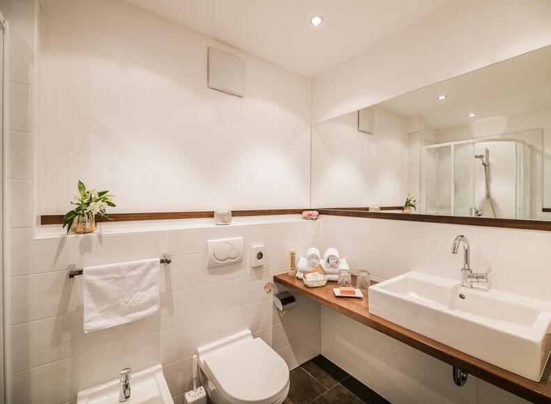 Badezimmer mit Dusche, Bidet, WC, Waschbecken und Spiegel
