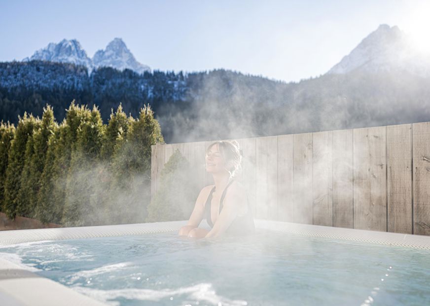 A woman is lying in the hot tub