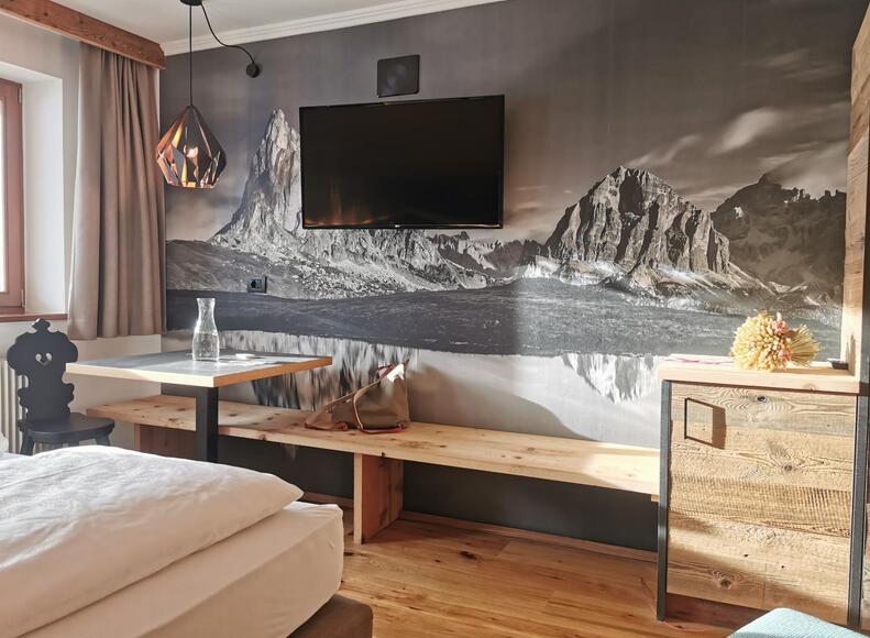 Suite Dolomiti con TV, mini frigo e piccolo tavolino con panca